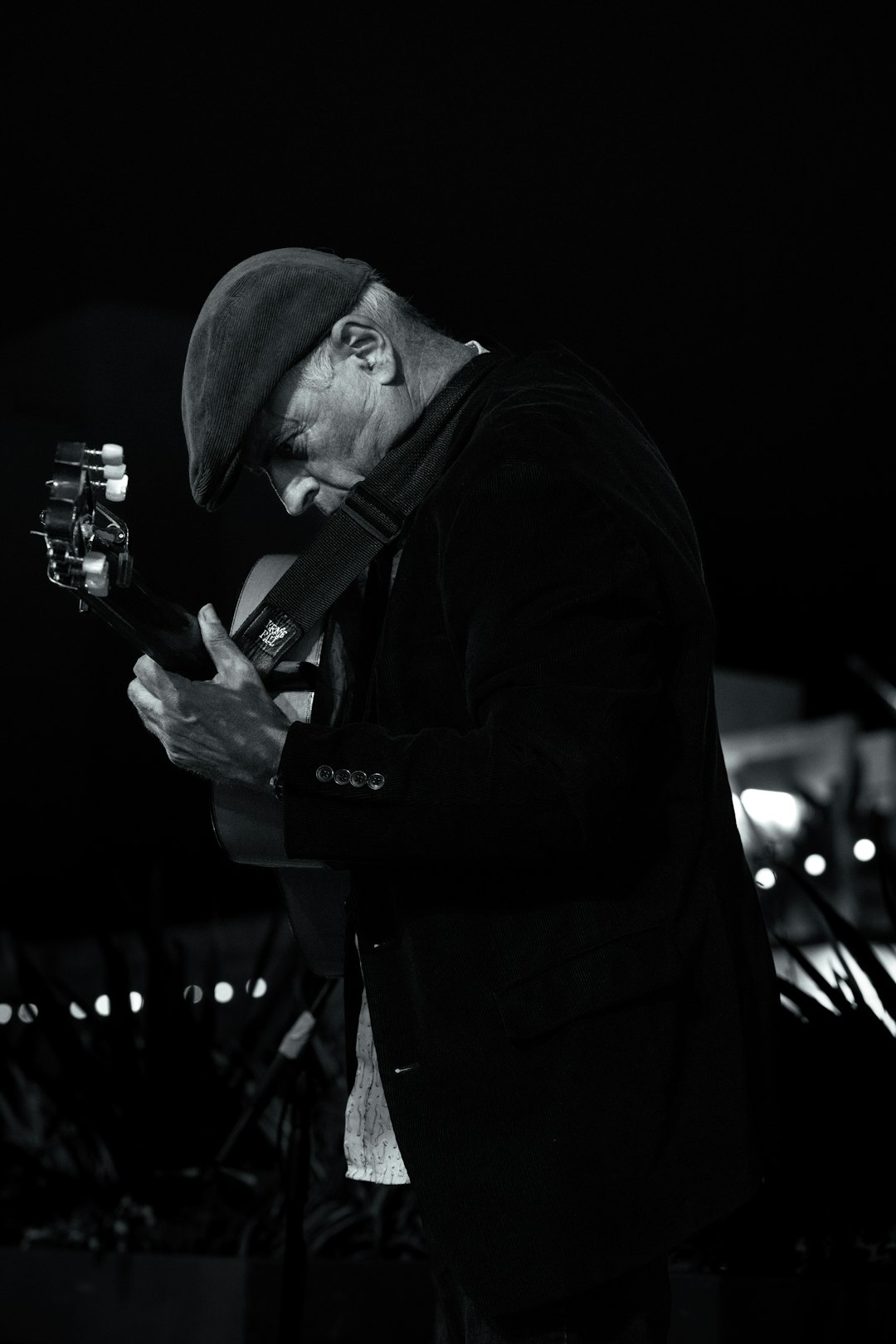 man-in-hat-playing-guitar-in-dim-lighting-mqkqazmbly8