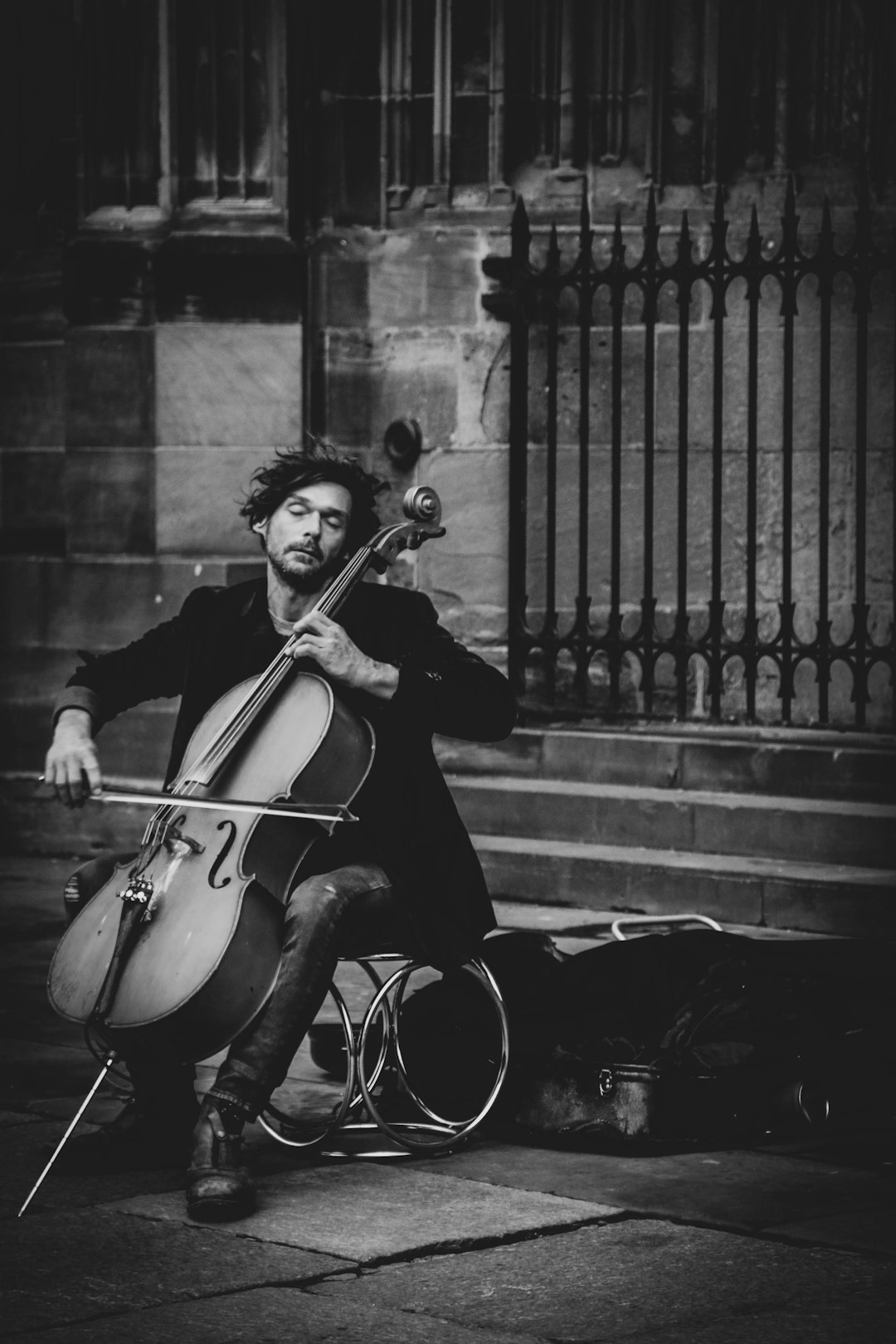 man-playing-violin-on-street-in-grayscale-photography-atd181puoxm